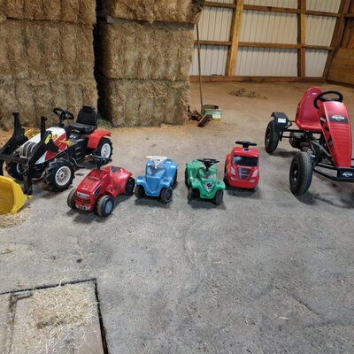 Kinderfahrzeuge wie ein Traktor, Bobycars und ein Kettcar für die kleinen Gäste des Bauernhofs.